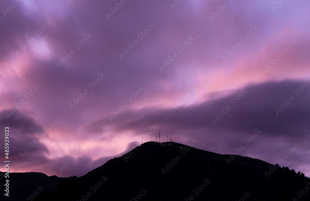 Purple long exposure sunset with Pichincha volcano silhouette seen from Quito city, Ecuador.