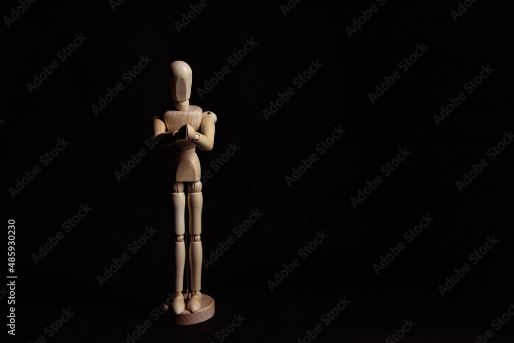 Wooden mannequin with folded hands. Symbol of prayer and religiosity Wooden mannequin with folded hands. Symbol of prayer and religiosity