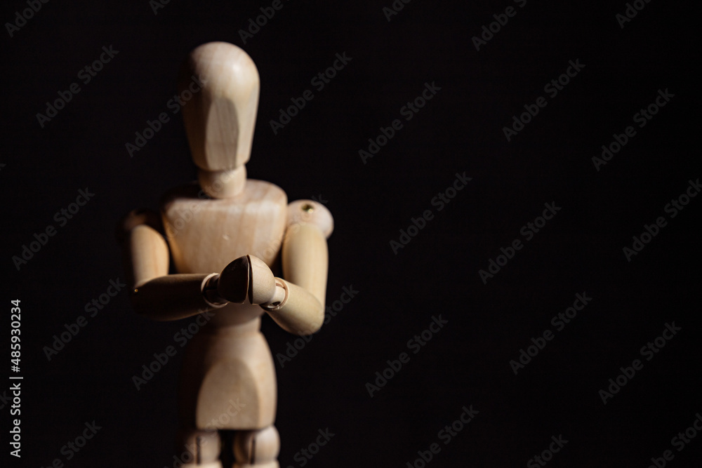 Wooden mannequin with folded hands. Symbol of prayer and religiosity Wooden mannequin with folded hands. Symbol of prayer and religiosity