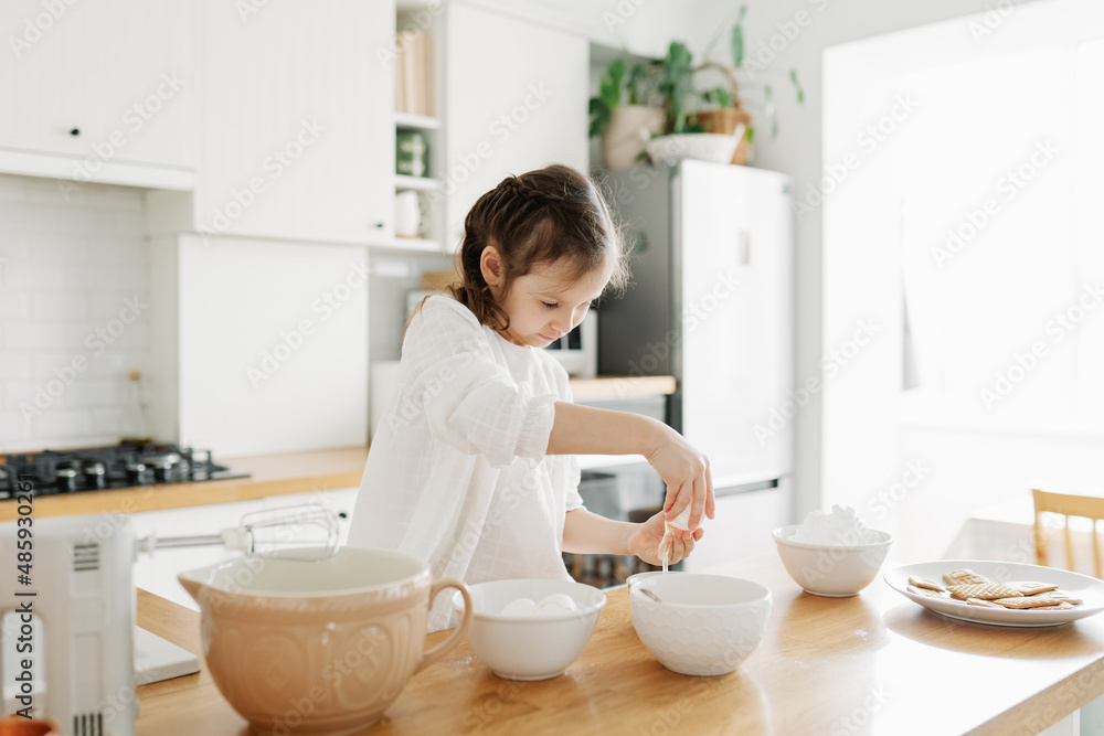 Adorable girl preparing icing pancakes at the kitchen. Concept of food preparation. Casual lifestyle photo series in real life interior Adorable girl preparing icing pancakes at the kitchen. Concept of food preparation. Casual lifestyle photo series in real life interior