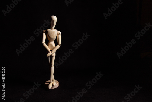 Wooden mannequin hiding genitals. Symbol of wanting to pee or trauma after rape