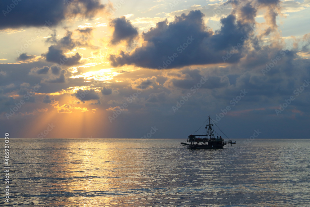 Blue Sea silhouette of the ship on the horizon. Sunset on the Ocean coast. Sea sunset Ship. Beautiful Seascape. Boat and sun reflection on the water. Beautiful sea at sunset .Ocean and sky background 