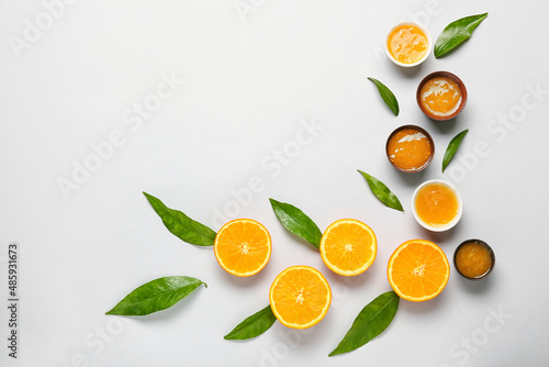 Composition with tasty orange jam and leaves on blue background