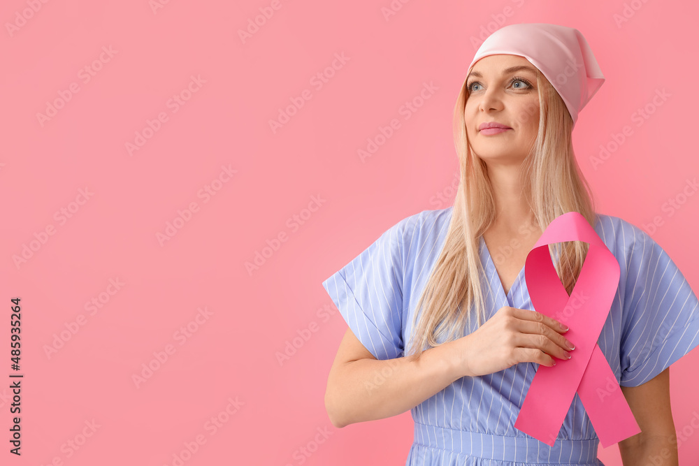 Woman in pink headscarf holding awareness ribbon on color background. Breast cancer awareness concept Woman in pink headscarf holding awareness ribbon on color background. Breast cancer awareness concept