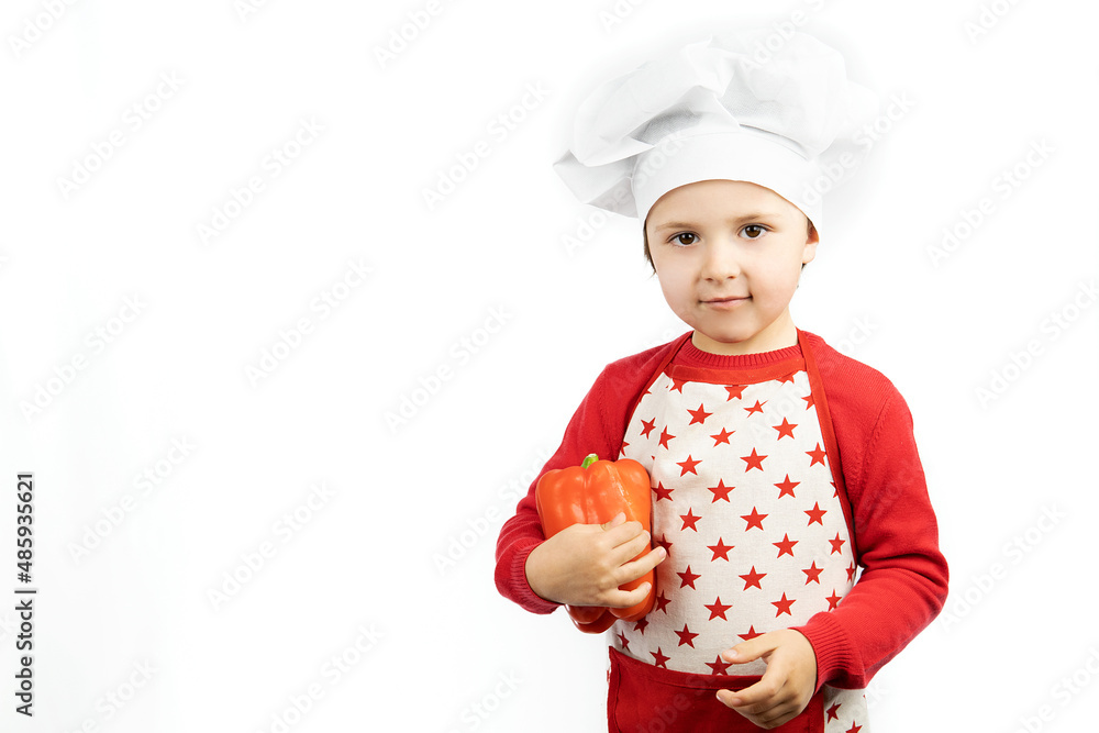 Happy teen boy in chef hat holds red pepper, isolated on white background. Happy teen boy in chef hat holds red pepper, isolated on white background.