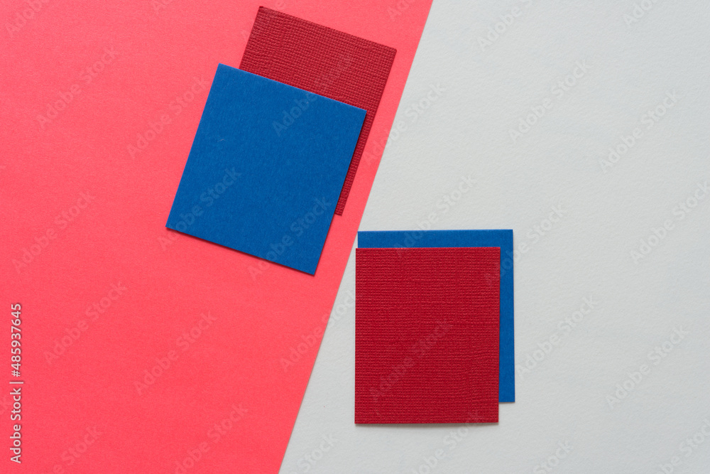 blue and red paper squares arranged on a light background blue and red paper squares arranged on a light background