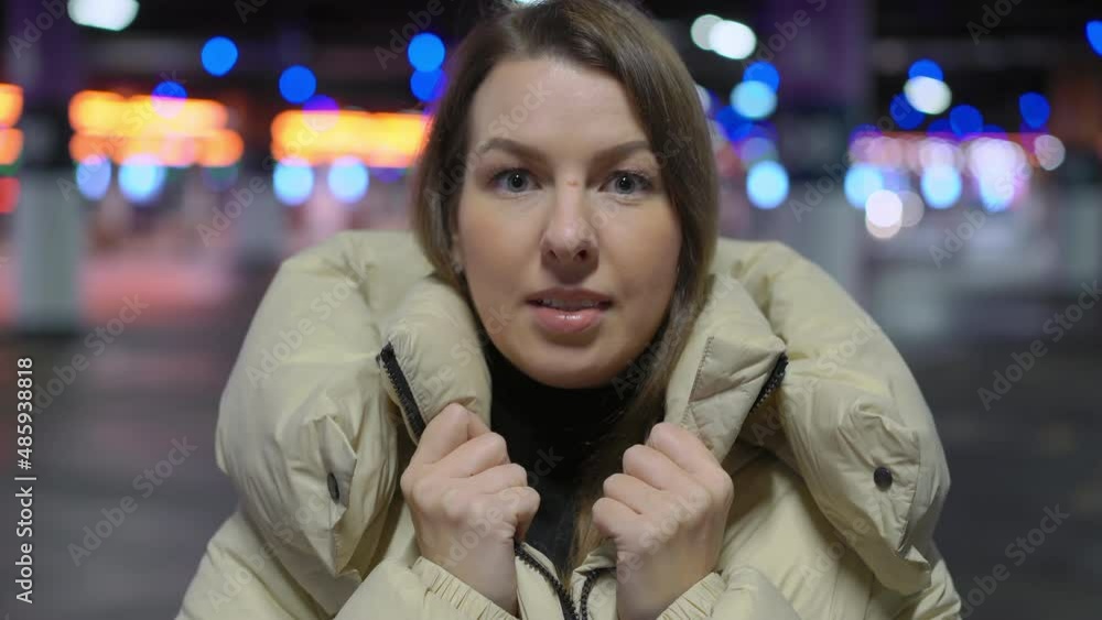 Young woman standing and looking at camera in underground parking garage. Young woman standing and looking at camera in underground parking garage.