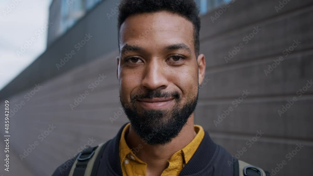 Close-up of young African-american man looking at camera in city. Close-up of young African-american man looking at camera in city.
