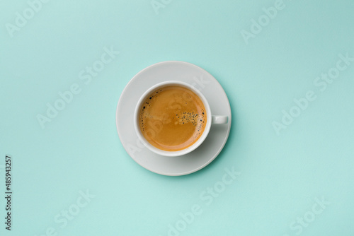 Cup of delicious coffee on color background, top view