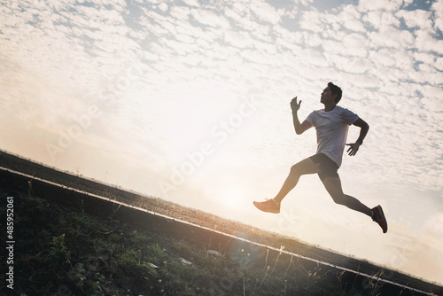 The runer runs on a red rubber running track, starting off using the starting block. Sports.Sprinter Leave the default block to track work. Young man running on the road running for fitness, exercise.