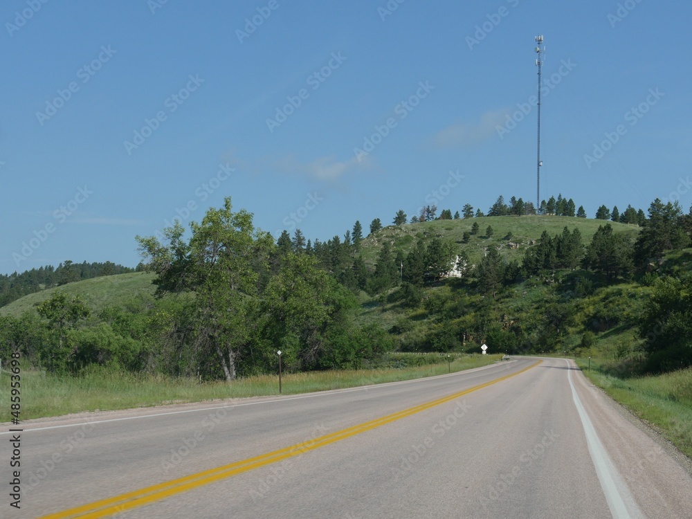Medium wide shot of a winding road with a cell tower in the distance in Custer, South Dakota Medium wide shot of a winding road with a cell tower in the distance in Custer, South Dakota