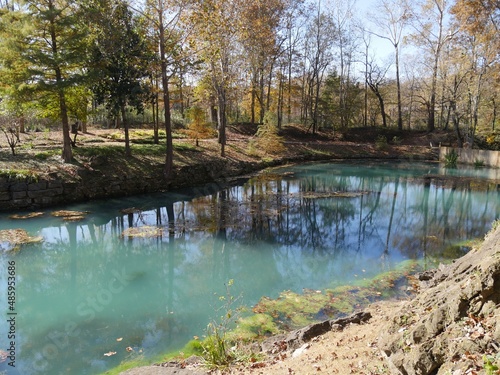 Blue waters of a spring with colorful trees in autumn photo