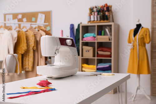Sewing machine and accessories on table in dressmaking workshop