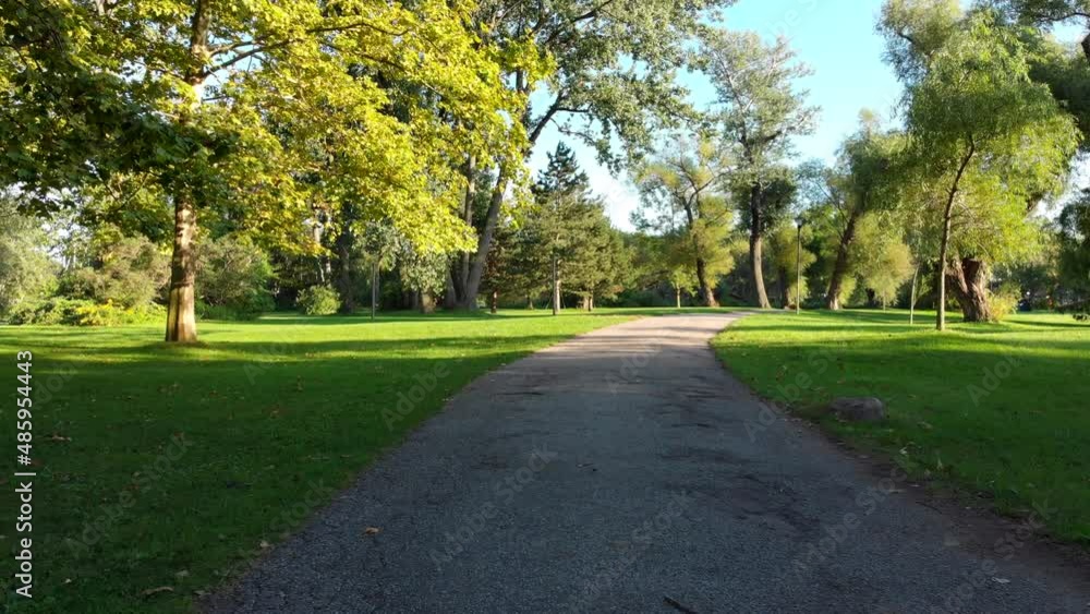 Stabilized POV shot, walking on footpath at an empty park on a beautiful summer day, tranquil scene, nature background. Stabilized POV shot, walking on footpath at an empty park on a beautiful summer day, tranquil scene, nature background.