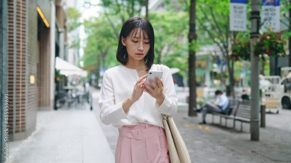 スマホを持って街を歩く女性 スマホを持って街を歩く女性