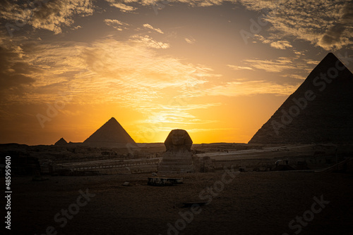 Archaeological complex of Great Egyptian Pyramids is located on the Giza plateau. second pyramid of Chephren khefren in the night light at sunset. sun sets behind the pyramid. sphinx at sunset