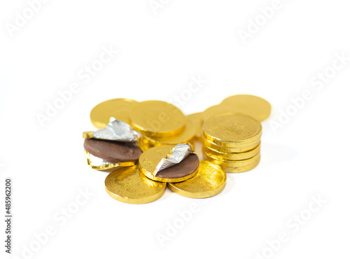 An image isolated group of a pile of gold coin chocolates as a snack and junk food on the white background.
