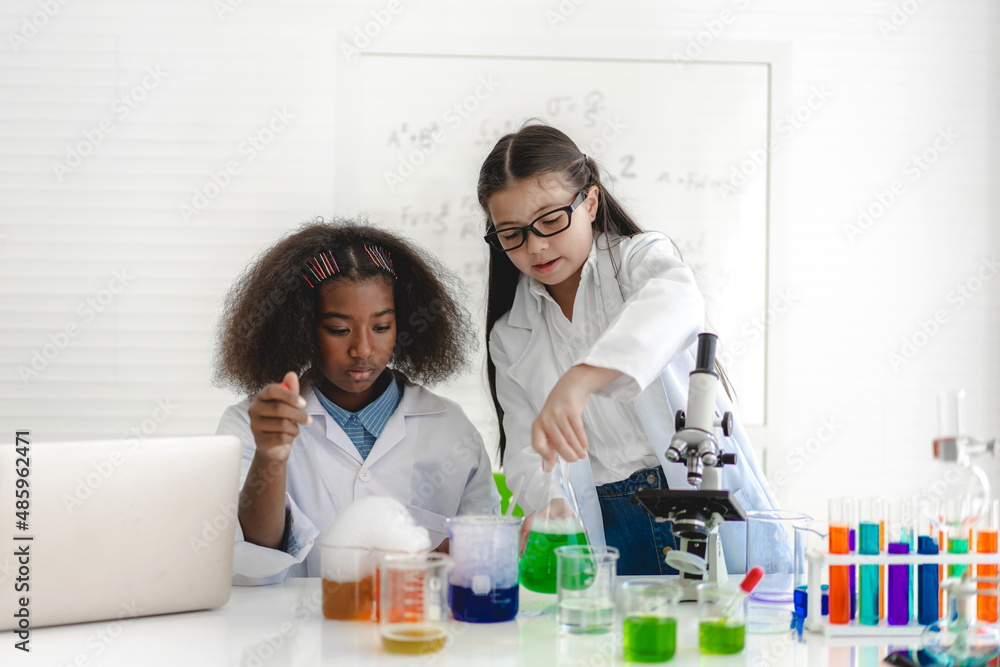 Group of teenage student learn and study doing a chemical experiment and holding test tube in hand in the experiment laboratory class on table at school.Education concept Group of teenage student learn and study doing a chemical experiment and holding test tube in hand in the experiment laboratory class on table at school.Education concept