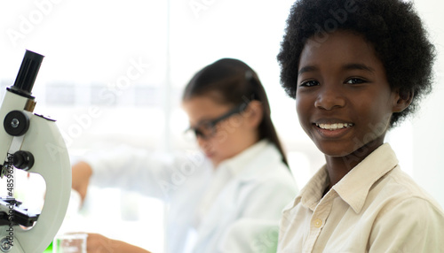 Group of teenage student learn and study doing a chemical experiment and holding test tube in hand in the experiment laboratory class on table at school.Education concept