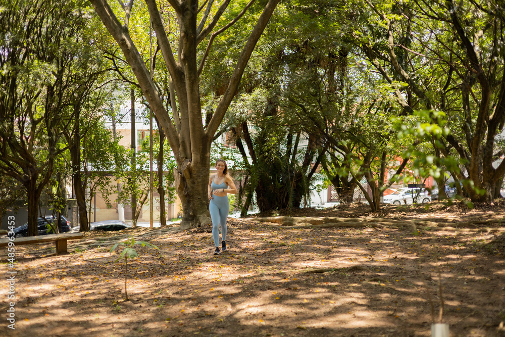 Fototapeta premium Young woman running and jogging at a park outdoors. Athlete female person during workout. High quality photo