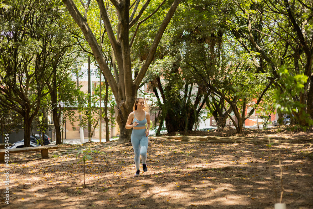 Young woman running and jogging at a park outdoors. Athlete female person during workout. High quality photo Young woman running and jogging at a park outdoors. Athlete female person during workout. High quality photo