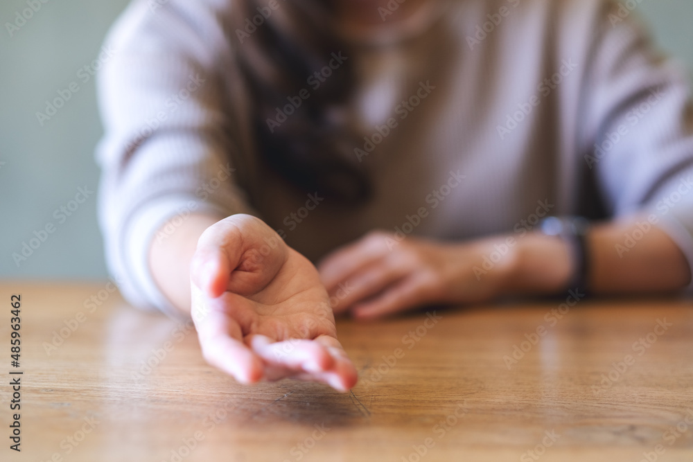 Blurred image of a young woman with reaching hand or giving hand to someone Blurred image of a young woman with reaching hand or giving hand to someone