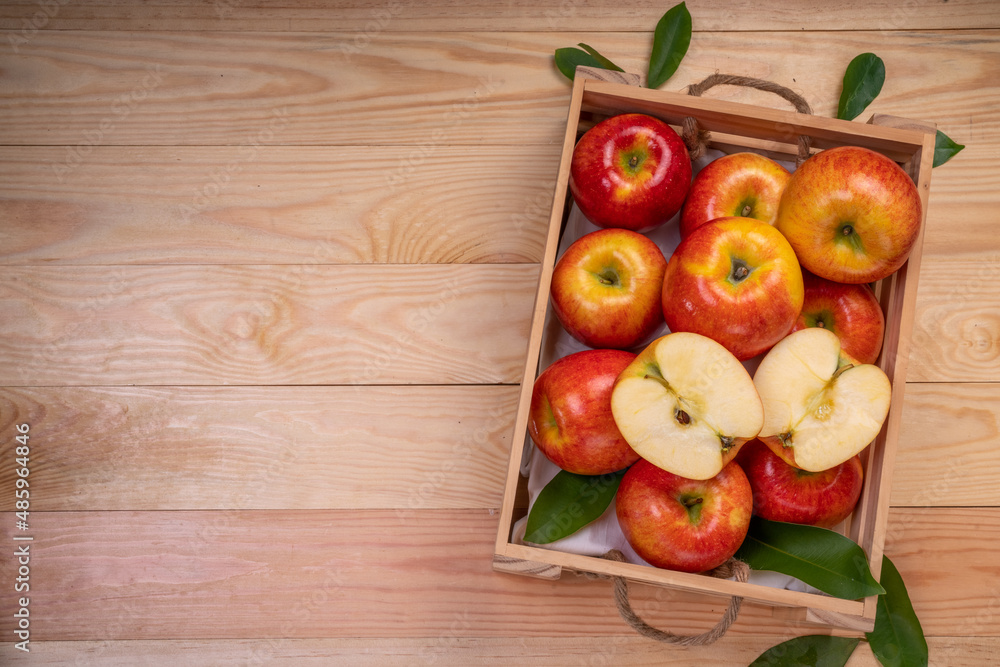 Fresh red Envy apple in wooden basket on wooden background. Envy apple on wooden box packaging ready to sell. Fresh red Envy apple in wooden basket on wooden background. Envy apple on wooden box packaging ready to sell.