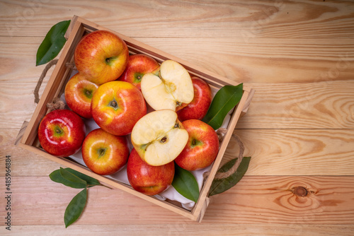 Fresh red Envy apple in wooden basket on wooden background. Envy apple on wooden box packaging ready to sell.