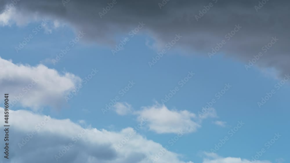 Puffy rain clouds floating at lue sky. Changing weather on sunny summer day. Puffy rain clouds floating at lue sky. Changing weather on sunny summer day.