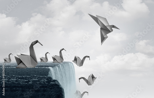 Adapt to survive concept as paper swans falling off a waterfall and one origami bird adapting new skills and flying away to safety. photo