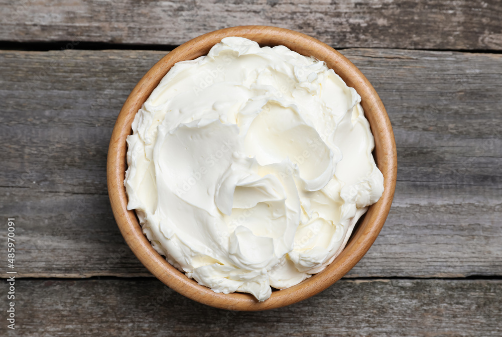 Bowl of tasty cream cheese on wooden table, top view Bowl of tasty cream cheese on wooden table, top view
