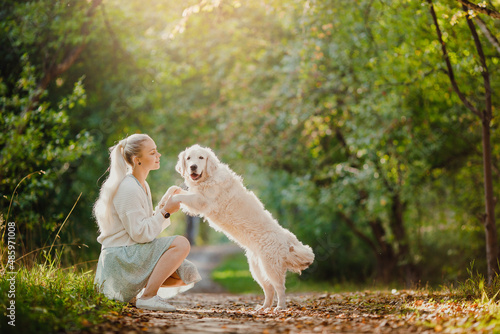 Young woman with Active, smile Happy golden retriever outdoors in grass park on sunny summer day