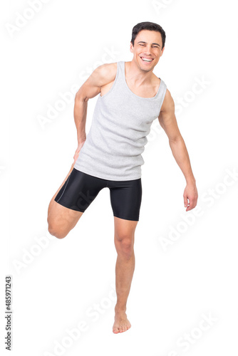 Cheerful sportsman stretching quadriceps muscle