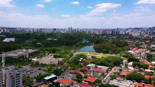 Flying towards Ibirapuera urban park with Sao Paulo skyline in distance. Brazil