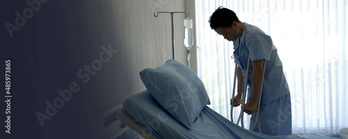 Canvas Print Adult Asian man injure walking with crutches while worry about medical fee in ho