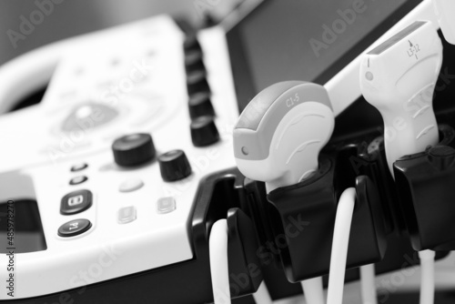 Medical equipment in the clinic. Modern ultrasound machine, scanners and sensors close-up. Black and white photography. photo