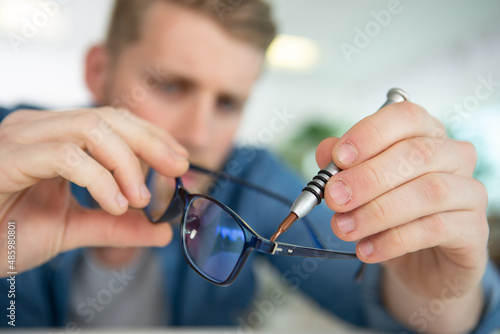 a man holding broken glasses photo