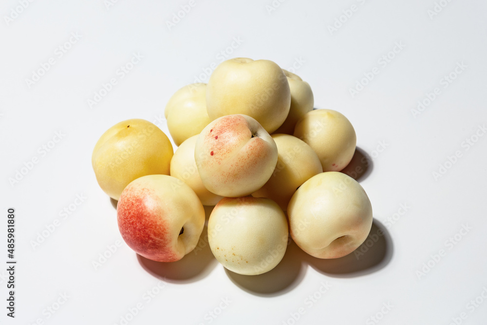 A bunch of farm-fresh white Uzbek nectarines on a white background