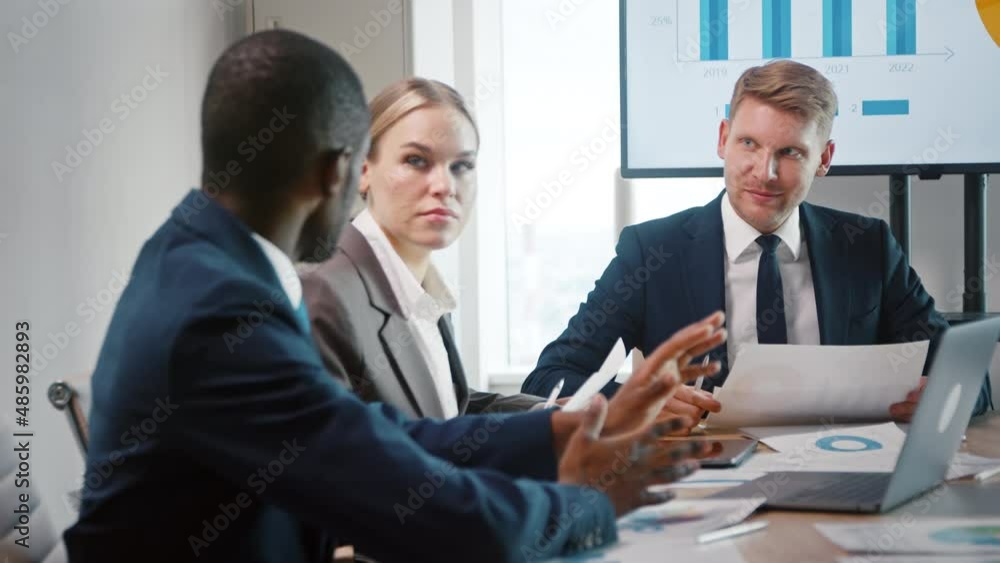 Meeting in the office: young businessmen of different nationalities discussing work processes Meeting in the office: young businessmen of different nationalities discussing work processes
