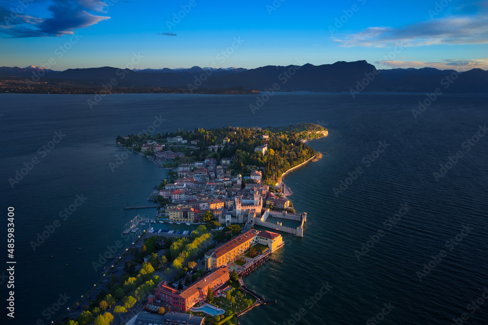 Aerial photography with drone, Rocca Scaligera Castle in Sirmione. Garda, Italy. Aerial view of Sirmione. Sirmione Castle, Lake Garda, Italy. The flag of Italy on the main tower of the castle.