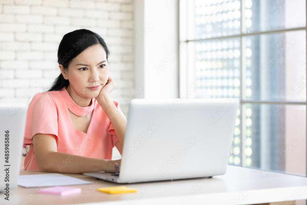 serious woman working laptop computer and thinking about work