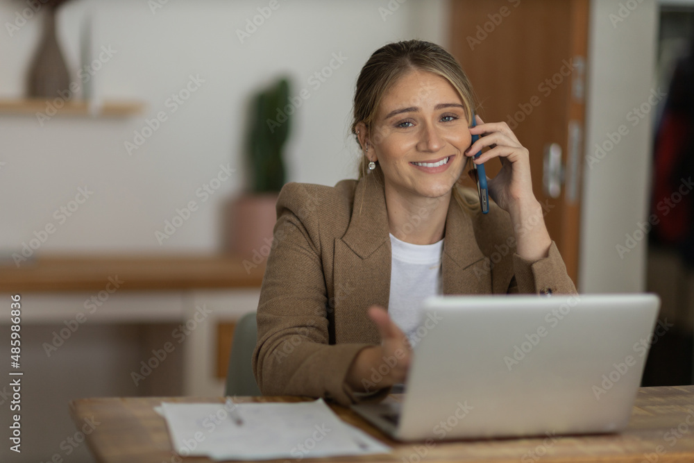 Young woman working at home with laptop and papers on desk. Home office concept. Young woman working at home with laptop and papers on desk. Home office concept.