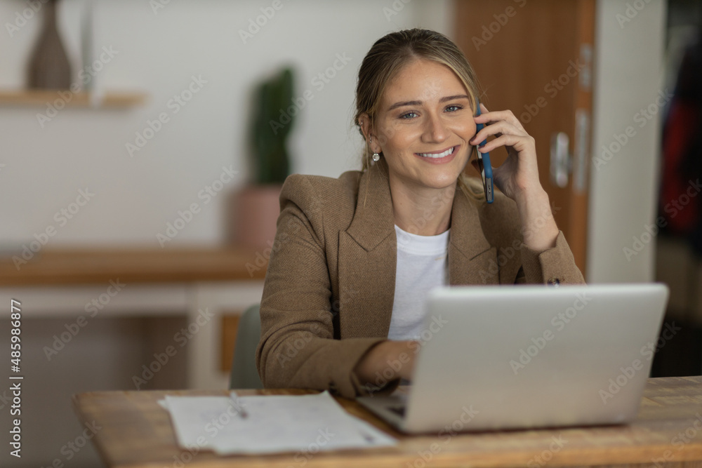 Young woman working at home with laptop and papers on desk. Home office concept. Young woman working at home with laptop and papers on desk. Home office concept.