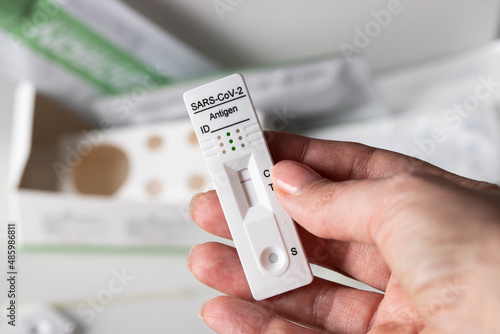 Female hand holding Covid-19 rapid antigen diagnostic device with negative result. Self testing and be safe concept