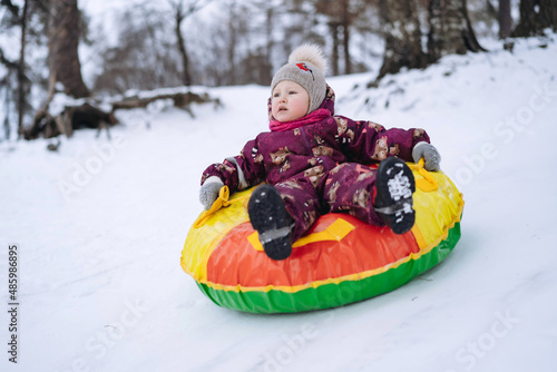 cute caucasian boys having a ride on snow tubing in winter park
