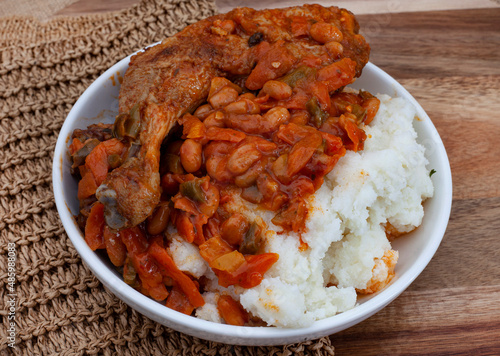 Traditional south African pap and roasted chicken, maize meal with chicken piece and chakalaka sauce photo