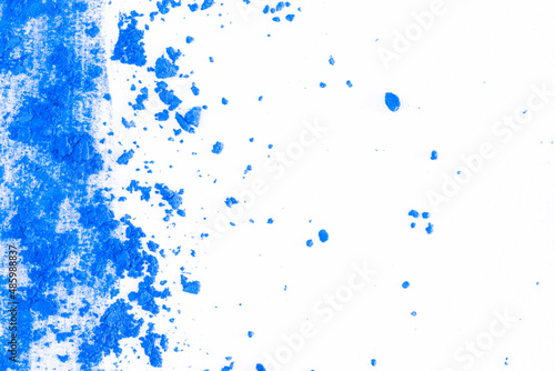Colored powder on a white background. Blue eyeshadows are scattered and smeared, makeup. Holi Colorful festival of colored paints powders and dust. A holiday of bright colors to entertain people.