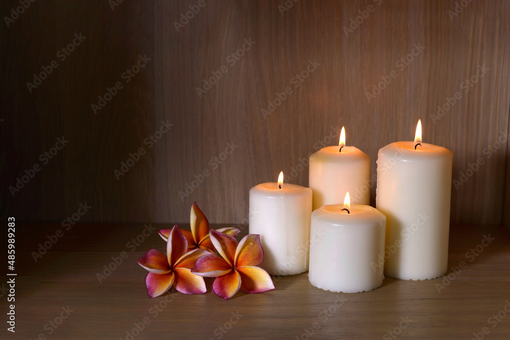 Burning candles and beautiful plumeria flowers on a wooden floor. Burning candles and beautiful plumeria flowers on a wooden floor.