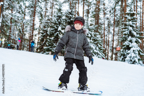 little boy learning to ride on snowboard