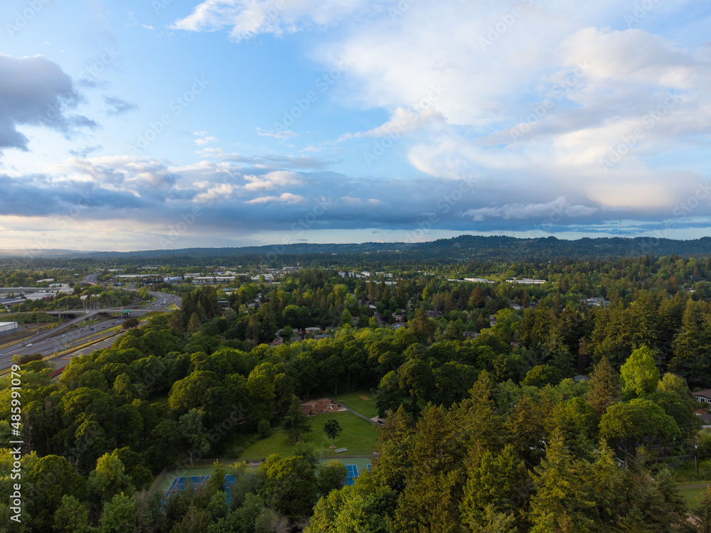 Shooting from a drone. Nice panoramic shot. Small green town. Lake, mountains, paved roads, large highway. Travel destinations, map, planning.Social issues, housing.